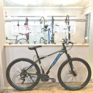 Trioblade 29" mountain bike with a medium alloy frame in Shimano Blue, featuring a Shimano 21-speed drivetrain, front suspension fork, and cable disc brakes.